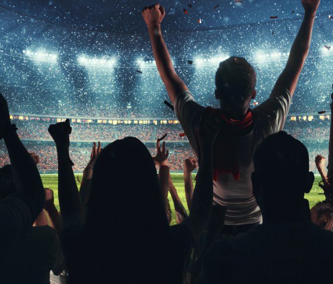 Fans celebrating the success of their favorite sports team on the stands of the professional stadium while it's snowing. Stadium is made in 3D.