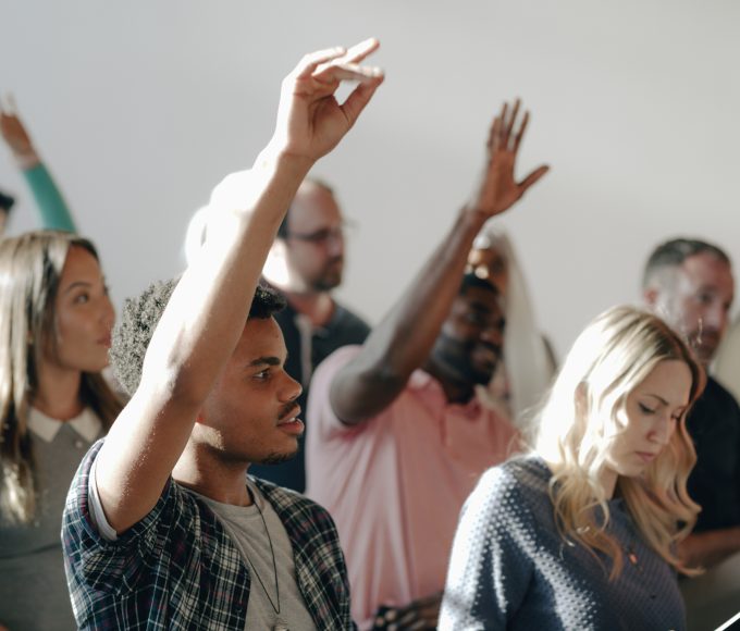People raising their hands in a seminar