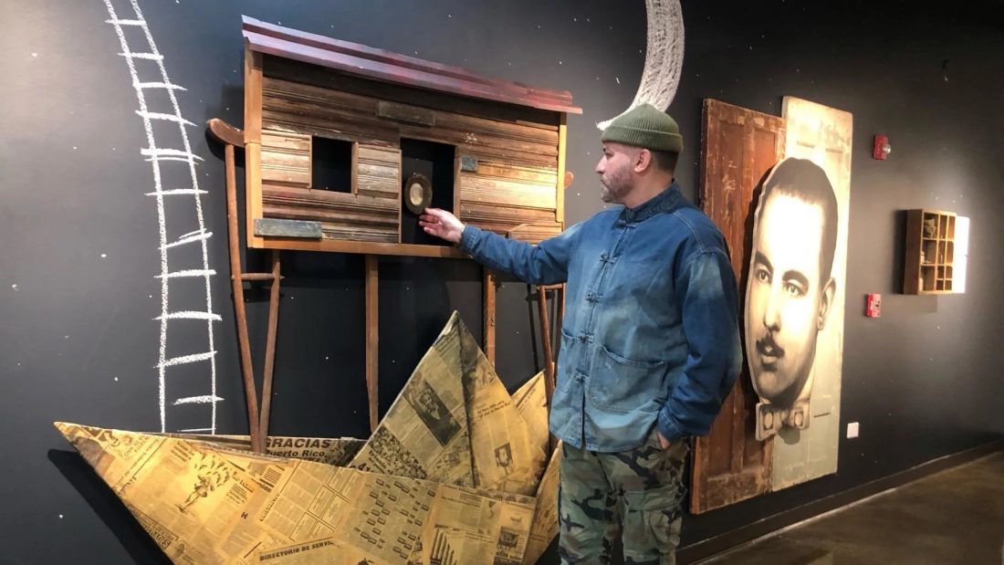 artist Adrián Viajero Román in front of one of this art pieces