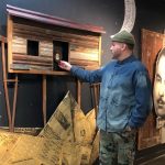 artist Adrián Viajero Román in front of one of this art pieces